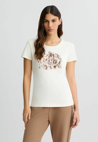 Crème kortemouwen t-shirt van zachte katoen, met een centraal grafisch ontwerp en metallic accenten en een ronde halslijn.