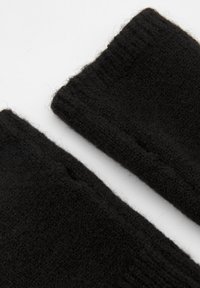 Mănuși negre, tricotate fără degete, cu o textură moale și manșetă în relief. Au un aspect ușor pufoș și deschideri mici pentru degete.