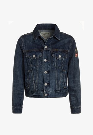 Giacca in denim blu scuro con colletto classico, due tasche sul petto e un patch della bandiera americana sulla manica destra. Bottoni e cuciture argentate visibili.