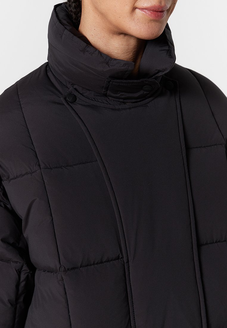 Schwarze gepolsterte Jacke mit hohem Kragen, ausgestattet mit Knopfdetails, stepptexturiert und mit einem schlanken Design. Geeignet für kaltes Wetter.