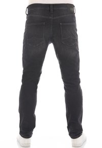 Svarta denimjeans med slim fit, med två bakfickor och diskreta sömnadsdetaljer. Midjebandet har en varumärkesetikett.