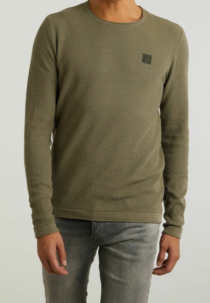 Oliwkowa sweter z długim rękawem o teksturowanym wzorze, okrągłym dekolcie i małej naszywce z logo na piersi. Rybkowany dół.