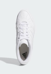 White athletic sneaker with smooth synthetic upper, perforated detailing, and laces. Features black Adidas logo insole and padded collar.