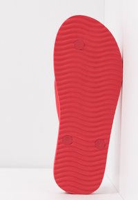 Red rubber shoe sole with a wavy texture, featuring labels "S" and "L" for sizing. The design is flat with a smooth edge.
