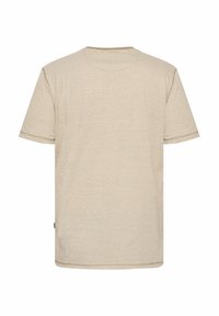 Camiseta de algodón beige con rayas horizontales en tonos más claros y más oscuros, de mangas cortas y con cuello redondo. Presenta una pequeña etiqueta de logo.