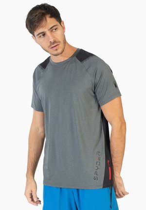 Grijze sportshirt met zwarte schouderaccenten, korte mouwen en een zijrits zak. "SPYDER" logo in het rood op de onderste voorkant.