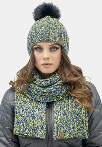 Berretto in maglia e sciarpa abbinata in blu e giallo, con pom-pom sulla cuffia e un motivo testurizzato. Logo in pelle attaccato alla sciarpa.