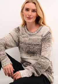 Maglione lavorato a maglia in toni attenuati di crema, grigio e marrone. Presenta maniche lunghe, polsini a costine e un collo rotondo con texture varia.