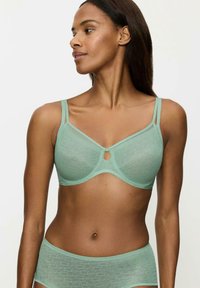 Jasnozielony biustonosz z geometrycznym wzorem, z fiszbinami, regulowanymi ramiączkami oraz małym wycięciem na środku.