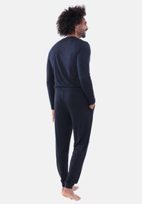 Zwart pyjama-set met lange mouwen en een ontspannen pasvorm, voorzien van een ronde halslijn en een elastische tailleband, gemaakt van zachte, gladde stof.