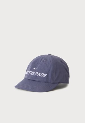 Blå Puma kasket med teksten "SET THE PACE" og Puma-logo broderet foran, mod en ensartet lys baggrund.