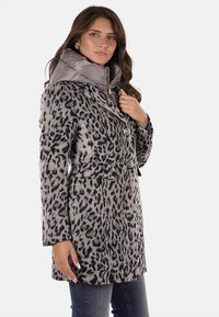 Abrigo de leopardo en tonos grises, con capucha extraíble brillante en gris, botones dobles y bolsillos laterales. Tejido texturizado.
