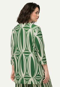 Blusa verde e crema a motivo con maniche a tre quarti, caratterizzata da un design astratto a foglia e una vestibilità ampia e fluida.