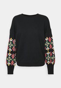 Sudadera negra con patrones bordados coloridos en rojo, rosa, verde y amarillo en las mangas. Corte relajado y puños de canalé.