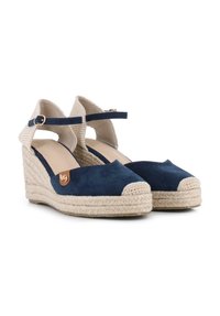 Espadrilles de cuña de color azul marino con parte superior de ante, correas de tejido trenzado en el talón, suela de yute y un acento dorado en el lateral.