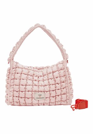 Sac à main matelassé rose avec une large bandoulière, motif carré texturé, étiquette rectangulaire et une bandoulière rouge amovible à côté.