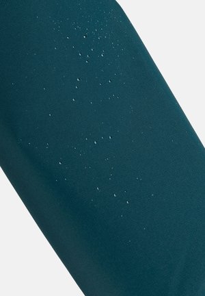 Tela verde azulado con una textura suave y gotas de agua en la superficie, indicando resistencia al agua. Brillo sutil en todo el material.