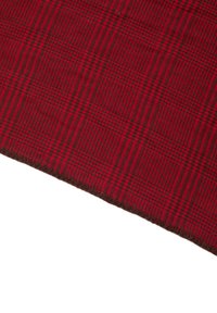 Tessuto a quadri rosso con una consistenza morbida, caratterizzato da un motivo a scacchi in rosso più scuro e nero, bordato da un rifinitura marrone solida.