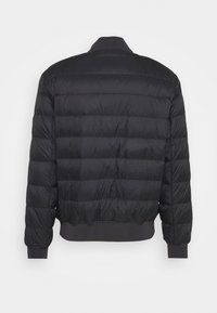 Mustat puhvitakki, jossa on tikattu muotoilu, uurrettu kaulus ja hihansuut. Ominaisuuksiin kuuluu lyhyt mitoitus ja sileä, pörröinen rakenne.