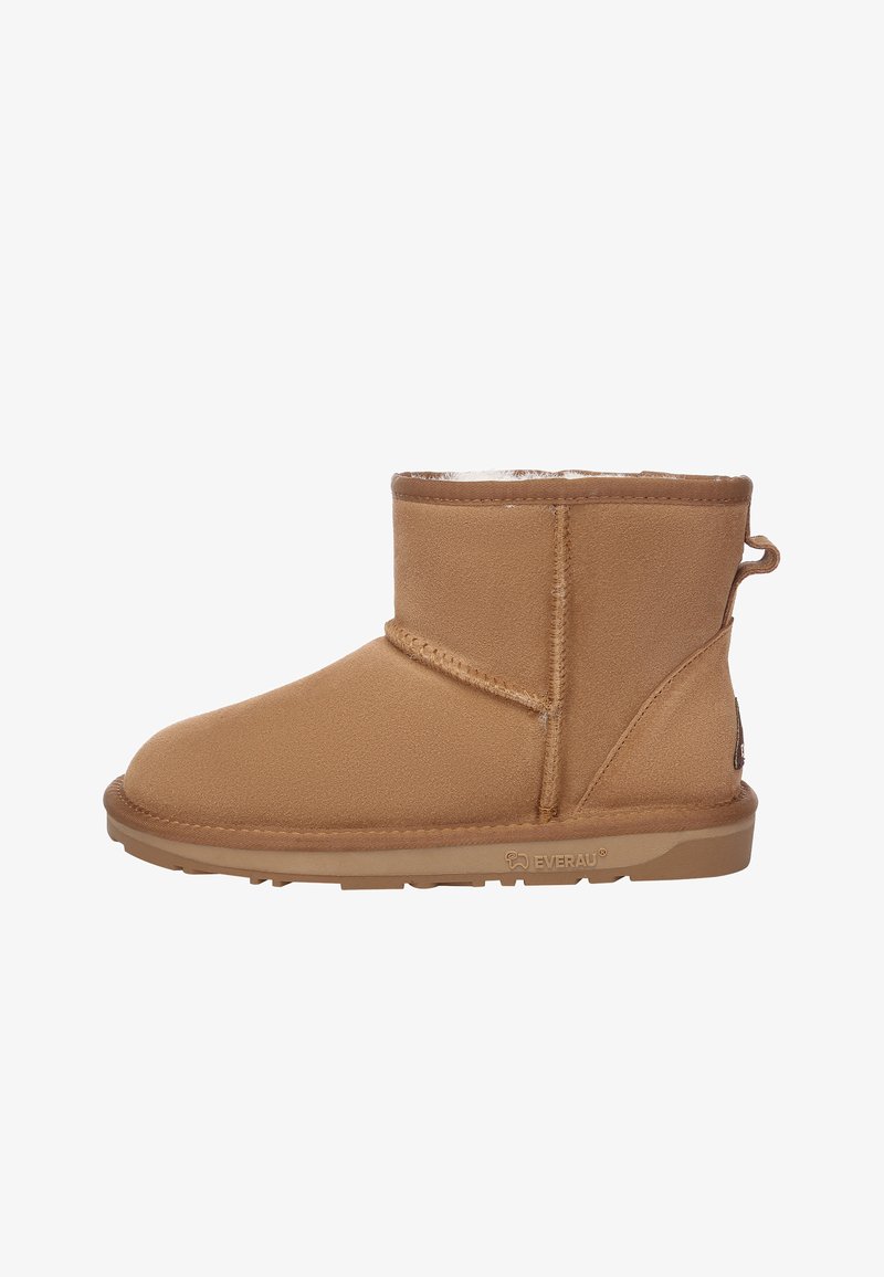 Beige Stiefelette aus weichem Wildledermaterial, mit runder Zehenpartie, Lammfellfutter und Gummisohle mit Zuglasche.