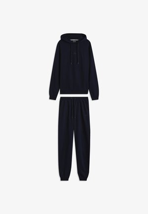 Conjunto de sudadera con capucha y pantalones deportivos azul marino, confeccionado en tela suave. La sudadera con capucha incluye cordón ajustable y bolsillo tipo canguro; los pantalones cuentan con una cintura elástica.