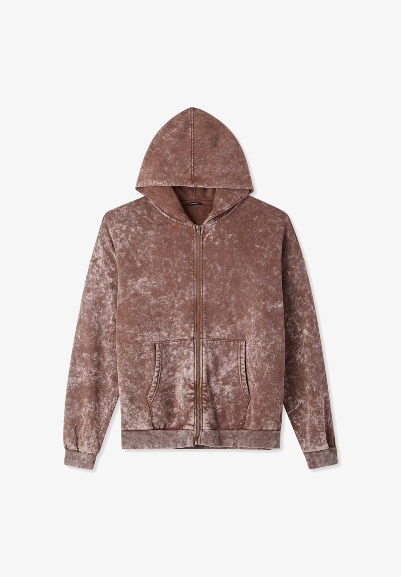 Felpa marrone con zip realizzata in materiale morbido e testurizzato, dotata di cappuccio e tasche frontali. Presenta polsini e orlo a coste, riflettendo un aspetto leggermente usurato.