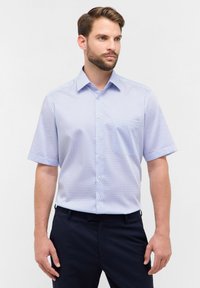 Kurzarm-Hemd mit Knöpfen aus hellblauem Stoff mit geometrischem Muster, ausgestattet mit einem Kragen und einer einzelnen Brusttasche.