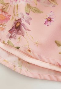 Tela floral en suave tono rosa, con acentos verdes. La textura es suave y los delicados detalles de costura resaltan el diseño.