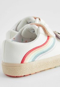 Hvide lædersneakers med regnbuebroderi i pastelfarver, med velcro-stropper og en struktureret gummisål. Indersiden har et dekorativt mønster.