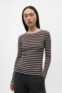 Bruin shirt met lange mouwen en crème horizontale strepen, met een ronde hals en geribbelde textuur. Gecombineerd met donkergrijze, gestructureerde broek.