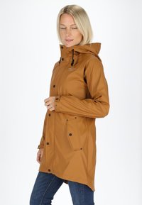 Giacca impermeabile marrone con cappuccio, bottoni a pressione e tasche anteriori. Tessuto liscio e vestibilità relaxed, dotata di cordini regolabili.