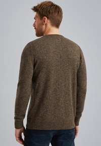 Pull en maille marron avec un motif texturé, col rond, poignets et ourlet côtelés ; porté avec un jean en denim foncé. Vue arrière présentée.