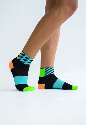 Schwarze Knöchelsocken mit geometrischen Mustern in Türkis, Neon-Grün und Orange, mit kontrastierenden Texturen im gesamten Design.