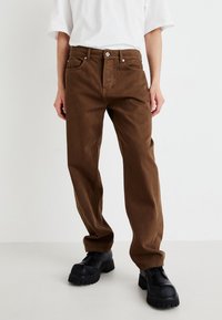 Pantaloni din bumbac maro cu croială dreaptă, dotati cu buzunare frontale și închidere cu nasture. Materialul are o textură netedă.