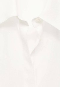 White dress shirt featuring a pointed collar, single button closure, and smooth cotton fabric with a subtle sheen.