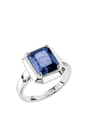 Silver ring with a large rectangular blue gemstone held by four prongs and engraved with "THOMAS SABO" on the band.