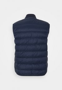 Chaleco acolchado sin mangas azul marino con costuras horizontales y cuello alto, visto desde atrás sobre un fondo claro liso.