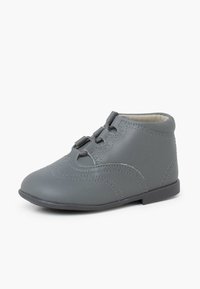 Šedá kožená bota s kulatou špičkou, šněrováním vpředu a dekoračním prošíváním. Nízký podpatek a hladká podšívka.