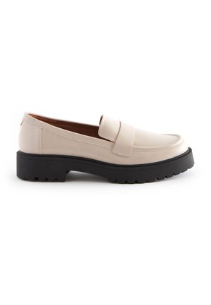 Beige leather loafers with a wide strap, rounded toe, and a black, ridged rubber sole. Smooth texture with stitching details.