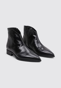 Botas de cuero negro hasta el tobillo con punta afilada, superficie lisa, cierre de cremallera lateral y tacón bajo en bloque.