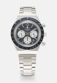 Stainless steel chronograph watch with a blue tachymeter bezel, black dial, white sub-dials, and a silver link bracelet.