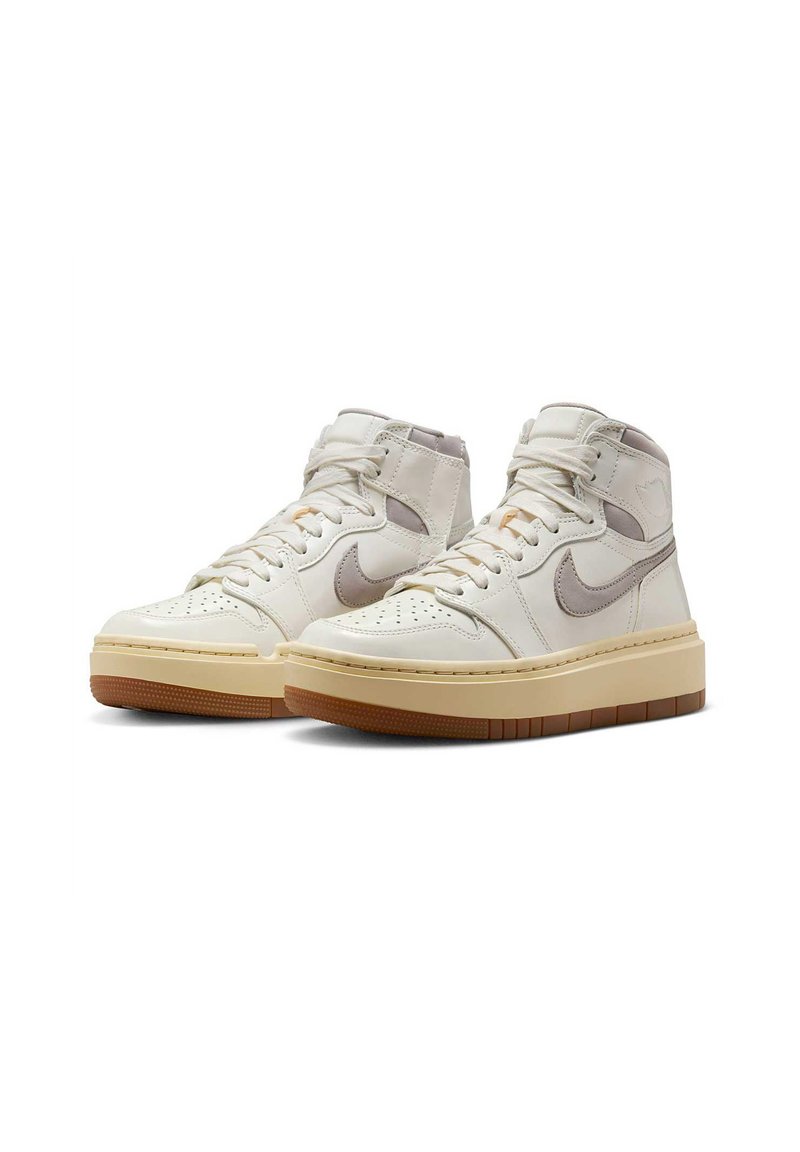 Des sneakers montants en cuir blanc cassé avec des accents gris, une pointe perforée et une épaisse semelle beige avec un dessous en caoutchouc marron.