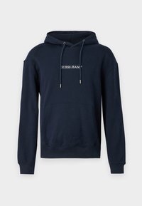 Sötétkék kapucnis pulóver pamut keverékből, kenguruzsebbel, húzózsinórral ellátott kapucnival és fehér "GUESS JEANS" logóval a mellrészen.