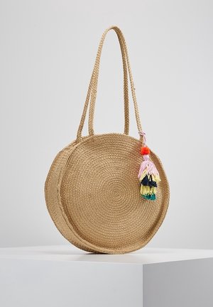 Sac à main rond en paille tressée avec de longues anses et une décoration de pompons colorés suspendue d'un côté.
