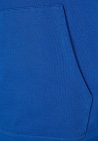 Nahaufnahme eines leuchtend blauen Stoffs mit einer vorderen Kängurutasche und sichtbaren Nahtdetails.