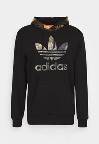 Svart hoodie i bomull med en huva invändigt med camomönster. Har en stor, mångfärgad Adidas-logotyp på framsidan och en framficka.