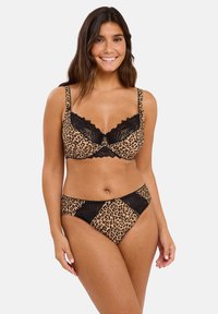 Ensemble de lingerie imprimé léopard avec des bordures et accents en dentelle noire. Le matériau semble doux avec une texture lisse et un motif distinct.