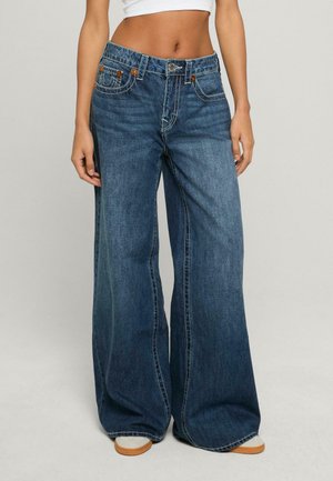 Wide-leg jeans in dark blue denim, featuring classic five-pocket design, contrast stitching, and a button closure at the waistband.