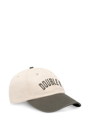 Cepure no bēša kokvilnas ar tumši zaļu malu. Uz tās izšūts teksts "DOUBLE Y" un seši ventilācijas caurumi. Ieliekts vizieris.