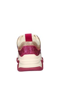 Sneaker with a cream fabric upper, pink textured accents, and a decorative jeweled back. Features a padded collar and a colored rubber sole.